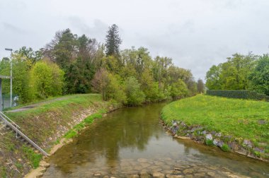 Bulutlu bir günde Leiblach nehri. Almanya ile Avusturya arasındaki sınır nehrine bak.