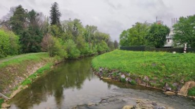 Horbranz, Avusturya - 10 Nisan 2024: Bulutlu bir günde Leiblach Nehri. Almanya ile Avusturya arasındaki sınır nehrine bak.