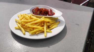 Kıvırcık sosis hafif körili ve patates kızartmasıyla servis ediliyor..