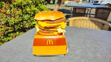 Frechen, Almanya - 6 Haziran 2024: konteynırda McDonald 's Big Mac sandviçi. Big Mac 'te üç parça susamlı çörek üzerine iki köfte, sos, marul, peynir, turşu ve soğan var..