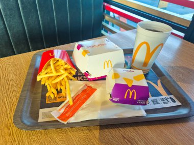 Hoofddorp, Hollanda - 9 Nisan 2025: McDonald 's menüsü patates kızartması, McÇıtır Yunan, Old Amsterdam Bitterballen, Coca-Cola.