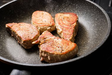 Cooking tasty tuna fish steak on frying pan