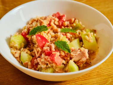 Ton balıklı bulgur salatası, salatalık ve yeşil otlu domates.