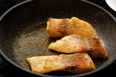 Kızartma tavasında sazan balığı bifteği pişiriyorum.