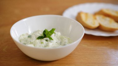 Lezzetli tzatziki salatası ve tabakta pasta.