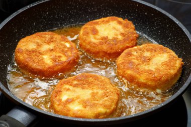 Kızarmış peynirli smazeny hermelin kızartma tavasında.