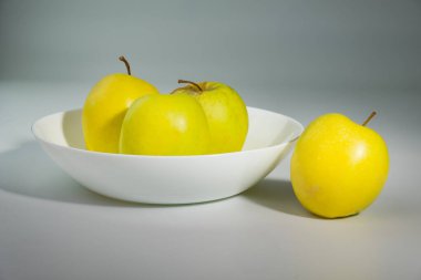 Gri arka planda kasede lezzetli taze elma meyvesi.