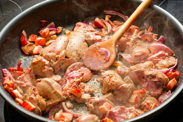 Domuz pastırmalı tavuk ciğeri ve kızarmış tavada kırmızı soğan pişiriyorum.