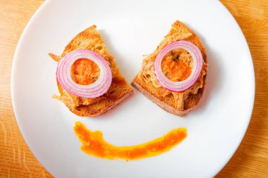 Lezzetli domuz eti ve beyaz tabakta kırmızı soğan.