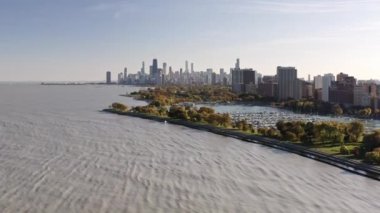 Panning down aerial view of downtown Chicago from Lake Michigan near Belmont Harbor on a sunny autumn day.