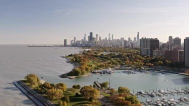 Beautiful aerial of the downtown Chicago skyline from above Belmont Harbor in Lakeview as two boats pass through the inlet on a sunny autumn afternoon.