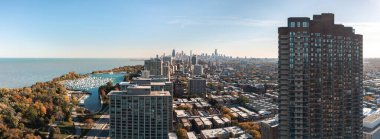 Cityscape aerial view overlooking Lakeview neighborhood and Belmont Harbor with the downtown Chicago skyline in the distance on a sunny autumn day.