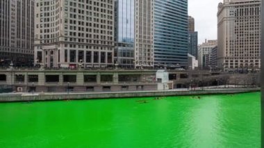Chicago, IL - 11 Mart 2023: Kayıklar ve kayıklar yıllık St. Paddy Günü kutlamaları sırasında taze boyanmış yeşil nehri geziyorlar.