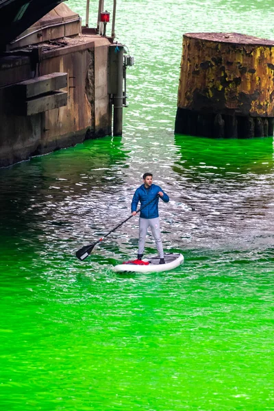 シカゴ 2023年3月11日 毎年恒例の聖パトリックの日イベント中に 新しく染められた緑の川のデュサブル橋の下にスタンドアップパドルボードを漕ぐ男 — ストック写真