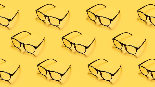 Modern Black Framed Reading Glasses Spectacles Repeated Bright Yellow Background Stock Photo