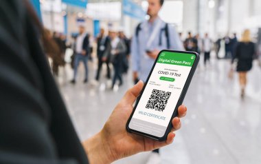 Cep telefonunda Covid19 'a karşı dokunulmazlık belgesi. İş kadınının elinde koronavirüs aşısı yapılmış bir akıllı telefon başvuru sertifikası var. Tıbbi Uygulama