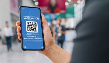 Covid19 'a karşı cep telefonundan Avrupa Kapsamlı Geçiş Belgesi. Kadının elinde koronavirüs aşısı yapılmış akıllı telefon uygulaması sertifikası var. Tıbbi Uygulama