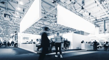 business people walking between trade fair booths at a public event exhibition hall, with banner and copy space for individual text  clipart