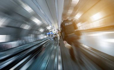 Havaalanında yürüyen bir polis.