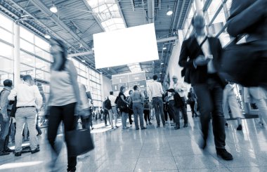 Bulanık insanların lobide yürüdüğü uluslararası ticaret fuarı