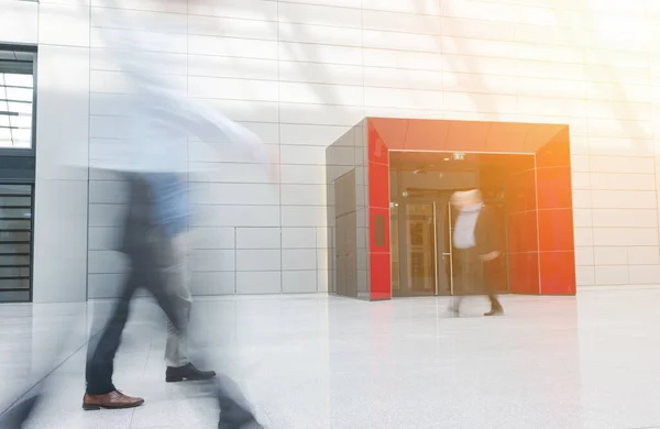 stock image Blurred business people go through hall in office