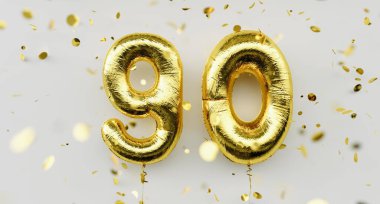 90 yaşında. 90. yıl dönümünde altın balonlar. Mutlu yıllar. Beyaz arka planda konfeti düşüşü.