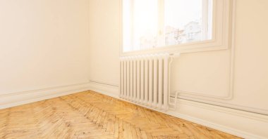 Berlin 'deki eski binada radyatörü olan boş parlak beyaz bir oda.