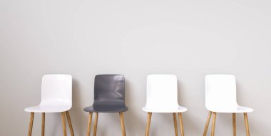 İç veya grafik arka planlar için duvarın önüne dizilmiş modern tasarım sandalyeleri. Sandalye farklı renkte işe alma pozisyonunu temsil etmek için metafor olarak kullanılabilir.