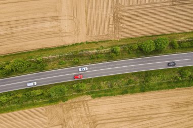 Kırsal ve tarlalardan geçen iki şeritli yoldaki trafiğin hava görüntüsü