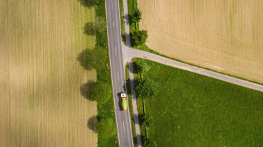 Kırsal kesimden geçen iki şeritli yolun hava manzarası ve arabalı tarlalar. İHA görüntüsü ve metin için boşluk kopyala
