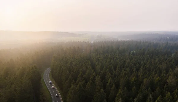 从空中俯瞰一条被浓雾笼罩的山路 上面是一片绿树成荫 上面是无人驾驶飞机 — 图库照片