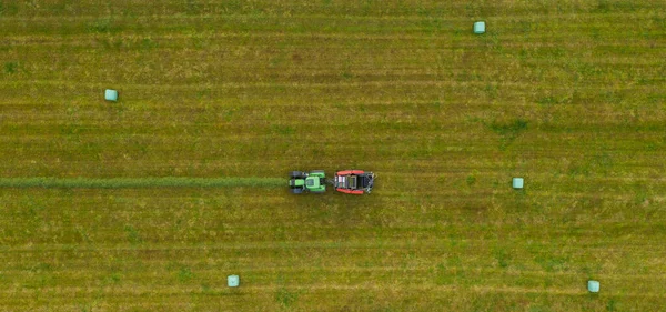 夏に緑のフィールドを刈るトラクターの空中ビュー ドローンショット — ストック写真