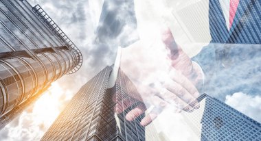 İyi bir anlaşmadan sonra el sıkışma süreci. Arka planda çift pozlama gökdeleni