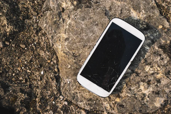 石の背景に壊れた画面のスマートフォン — ストック写真
