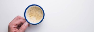 Adam beyaz bir masada bir fincan kahve tutuyor. Bireysel metinler için fotokopi alanı var.