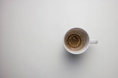 Bireysel metinler için kopyalama alanı olan beyaz bir masanın üzerine boş kahve fincanı. 