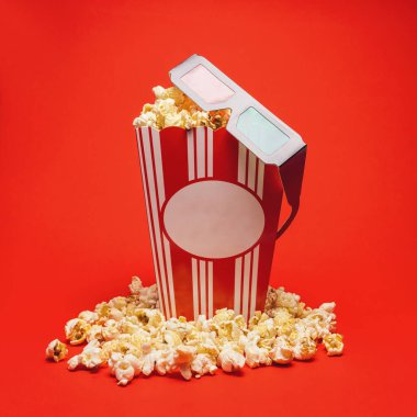 Kırmızı arka planda 3 boyutlu gözlüklü patlamış mısır kutusu, sinema, film ve eğlence konsepti resmi