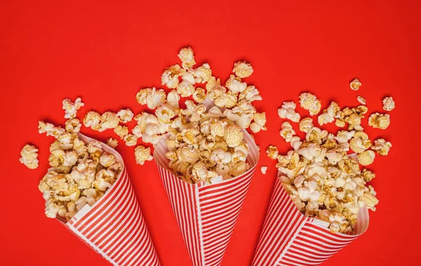 Popcorn Tumpah Dalam Kantong Kertas Pada Latar Belakang Merah Bioskop — Stok Foto