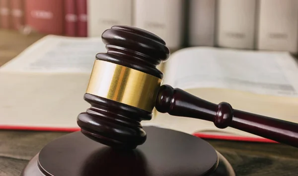 stock image wooden judge gavel in a lawyer office in front of a law books. ideal for websites and magazines layouts