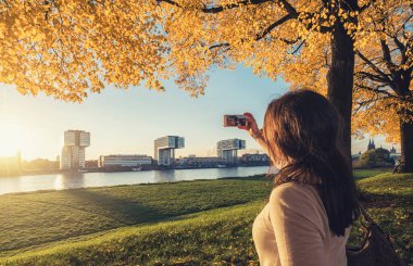 Genç bir kadın Köln, Almanya 'da Rhien sahilinde selfie çekiyor.