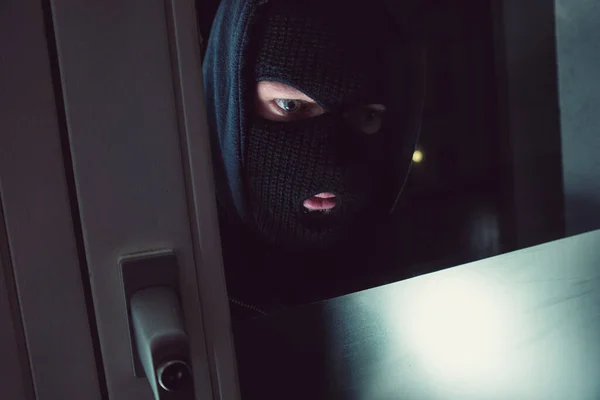 夜に家を覗き込むマスクのバーグラー — ストック写真