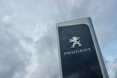 AAACHEN, ALMANLIK FEBRUARY, 2017: bulutlu gökyüzüne karşı Peugeot bayii tabelası. Peugeot Fransız otomobil üreticisi ve Groupe PSA 'nın bir parçasıdır..