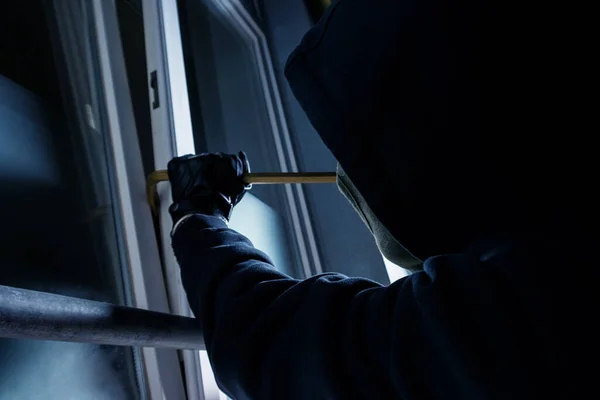 窃贼用撬棍闯入受害人的房子窗户 — 图库照片