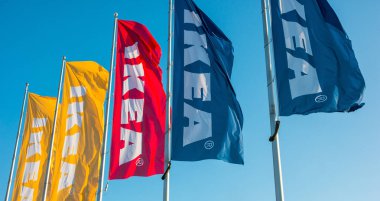 HEERLEN, NETHERLANDS FEBRUARY, 2017: IKEA mağazasında gökyüzüne karşı bayraklar. IKEA dünyanın en büyük mobilya perakendecisi ve mobilya montajı için hazır satıyor. 1943 'te İsveç' te kuruldu..