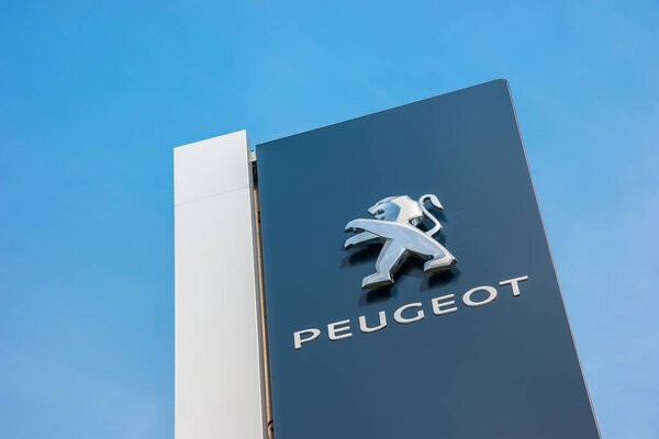 МАРТ ГЕРМАНИЯ, 2017: Дилерский знак Peugeot на фоне голубого неба. Peugeot является французским производителем автомобилей и частью Groupe PSA.
