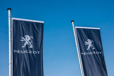 Peugeot Mağazası 'nda Peugeot bayrakları mavi gökyüzüne karşı. Peugeot, Fransız otomobil markası, PSA Peugeot Citroen 'in bir parçası..