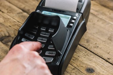 Süpermarkette kart okuyucuda şifresini yazan bir adam.
