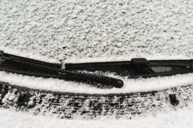 Karla kaplı ön camı olan araba.