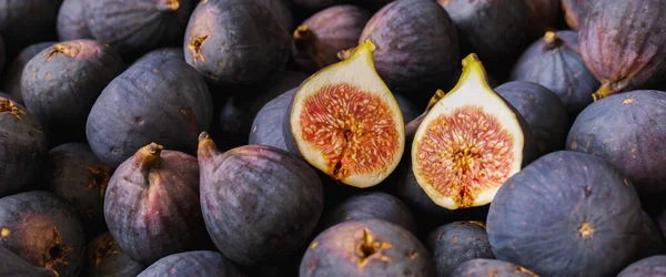 stock image Fresh ripe figs with halved fig as background, Tropical fruit