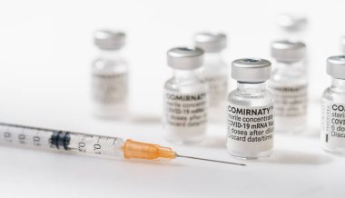 BERLİN, ALMANY HAZİRAN 2021: COVID-19 mrna biontech pfizer SARS virüs aşı ampulleri. Beyaz arka planda COMIRNATY MRNA aşısı. SARS COVID-19 virüsüne karşı COMIRNATY aşısı içeren şırınga.